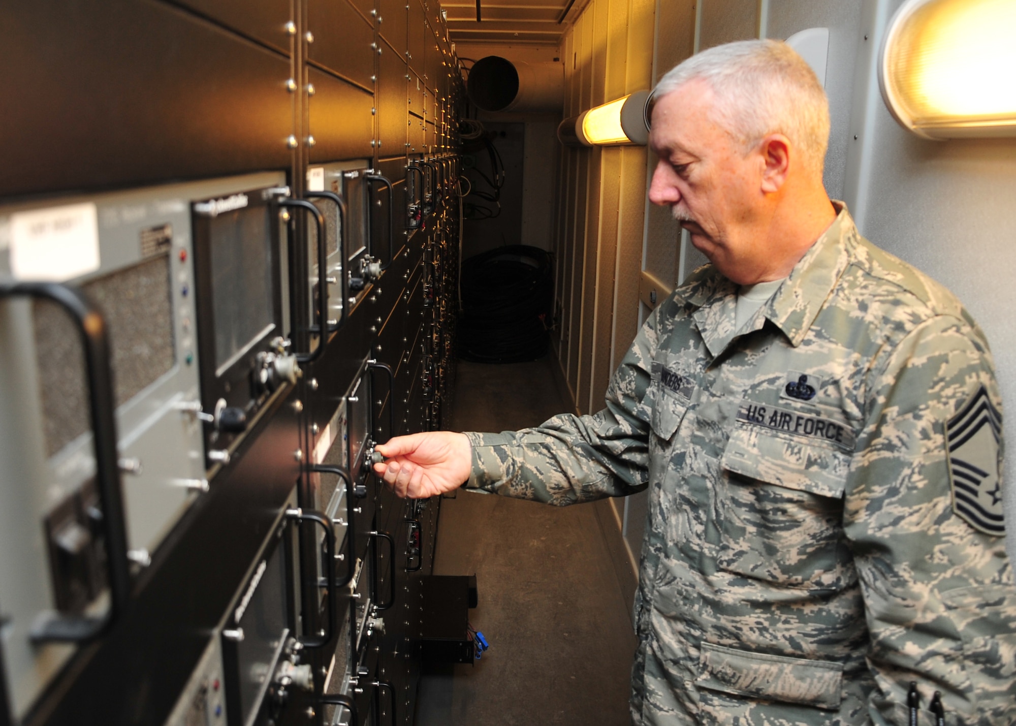 Chief Master Sgt. Al Flanders, 727th Expeditionary Air Control Squadron maintenance superintendant, familiarized himself with the local radio system at the new Battlespace Command and Control Center Theater, or BC3-T, at an undisclosed location in Southwest Asia, April 9, 2014. Part of the BC3-Ts mission is to provide critical tactical air command and control, integrated air and missile defense, air tasking order and airspace control order execution capability for the combined air forces component  commander. Flanders is deployed from the 117th Air Control Squadron at Hunter Army Airfield in Savannah, Ga., and is a native of Pembroke, Ga. (U.S. Air Force photo by Staff Sgt. Michael Means/Released)