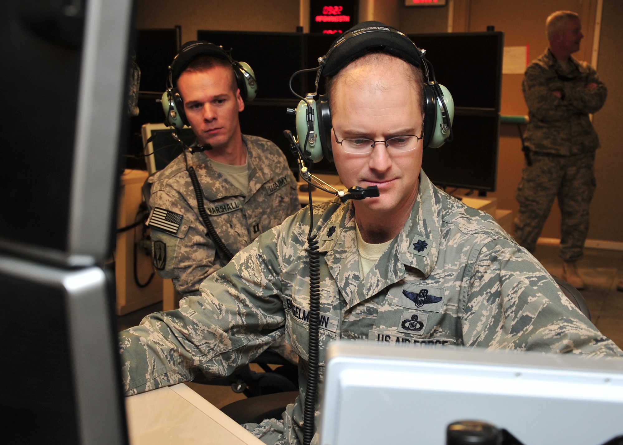 U.S. Air Force Lt. Col. Brett Bosselmann, 727th Expeditionary Air Control Squadron mission crew commander, and U.S. Army Capt. Christopher Marshall, 727 EACS air defense artillery fire control officer, familiarize themselves with the new Battlespace Command and Control Center Theater, or BC3-T, at an undisclosed location in Southwest Asia, April 9, 2014. The BC3-T provides a capability to develop coalition readiness for the wing with gulf coast countries, through a combined operations area. Bosselmann is deployed from Joint Base Lewis-McChord, Wash., and is a native of Gig Harbor, Wash. (U.S. Air Force photo by Staff Sgt. Michael Means/Released)
