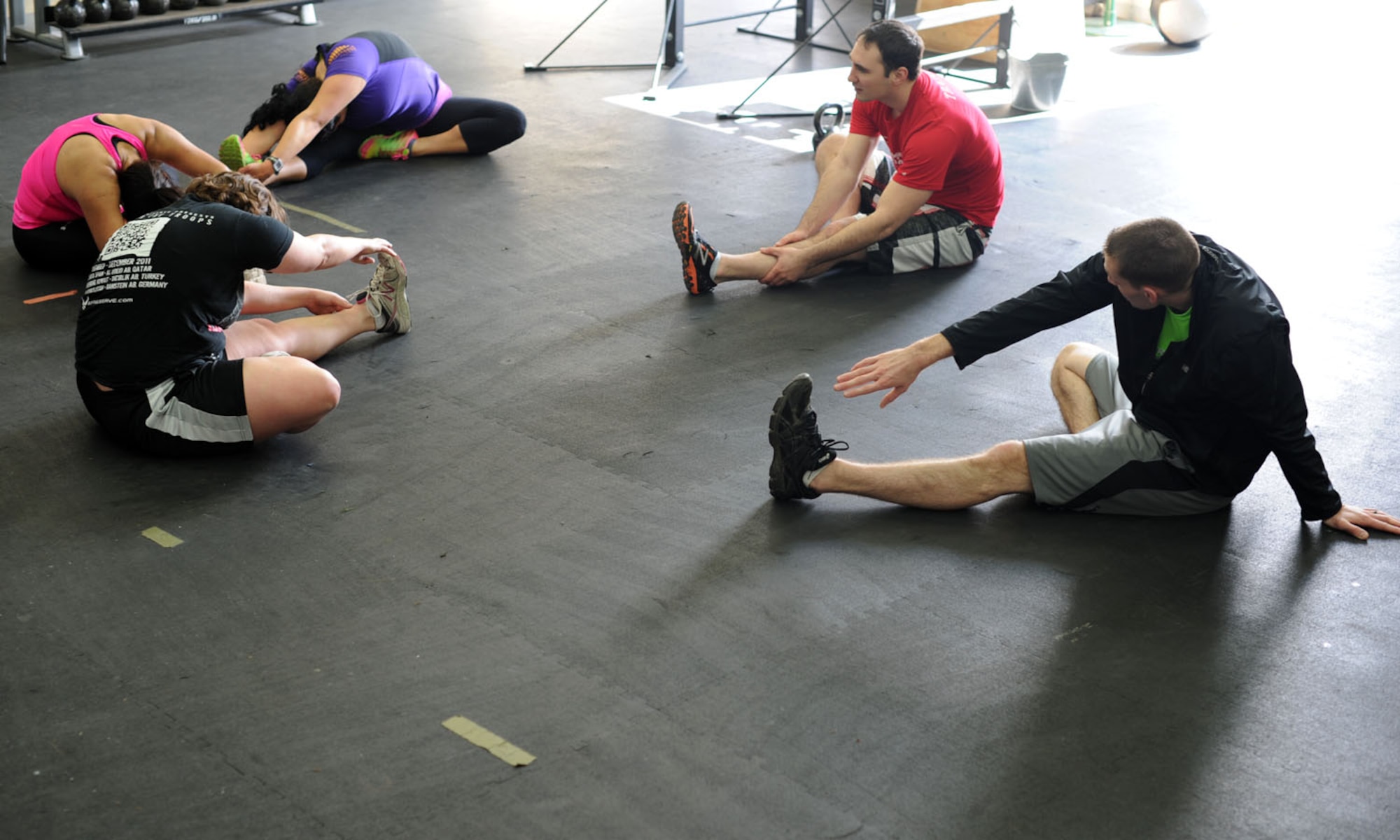 Combat Fitness Center fundamentals class participants stretch after completing the workout of the day April 9, 2014, at Spangdahlem Air Base, Germany. The trainers modify the workout to each participant’s ability. (U. S. Air Force photo by Airman 1st Class Dylan Nuckolls/Released)