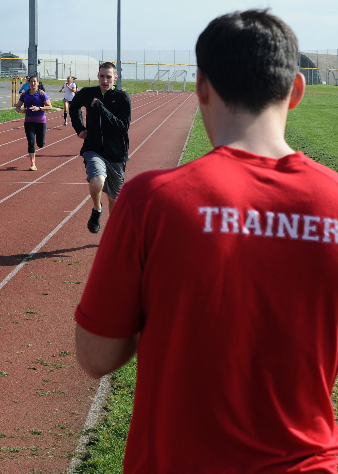 U. S. Air Force Senior Airman Nicholaus Grassl, a 52nd Contracting Squadron contracting specialist and level one certified trainer, keeps track of time during a Combat Fitness Center fundamentals class April 9, 2014, at the base track at Spangdahlem, Germany.  The Combat Fitness Center offers the class Monday through Friday in the morning and afternoon. (U. S. Air Force photo by Airman 1st Class Dylan Nuckolls/Released)