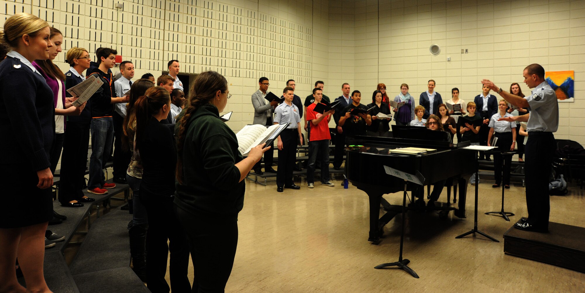 Tech. Sgt. Tate Armstrong conducts a group of music students and The U.S. Air Force Band’s Singing Sergeants as they harmonize together during an Advancing Innovation Through Music Chamber Ensemble Recital event at Eastern Michigan University in Ypsilanti, Mich., April 9, 2014. The two groups performed together during an evening concert at the university as part of the Band’s 2014 spring tour program. Armstrong, a native of Bethlehem, Pa., is a tenor vocalist with the Singing Sergeants, the official chorus of the U.S. Air Force. (U.S. Air Force photo/Master Sgt. Tammie Moore)