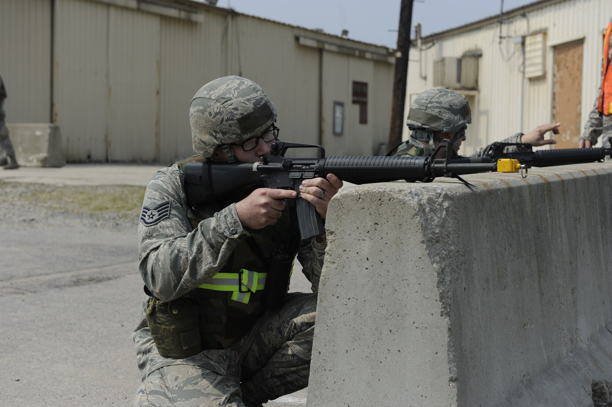 Staff Sgt. John Dodd, 8th Civil Engineer Squadron pavements and heavy equipment craftsman, defends the 8th CES compound during a training exercise at Kunsan Air Base, Republic of Korea, Apr. 10, 2014. The 8th SFS trained the Red Devils on communication tactics, apprehending suspects and manning defensive positions. (U.S. Air Force photo by Staff Sgt. Jessica Haas/Released)