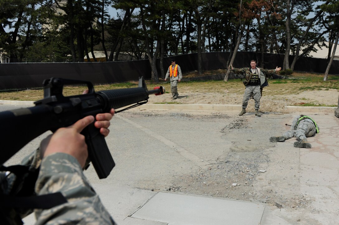 Staff Sgt. Souridet Thongrivong, 8th Civil Engineer Squadron pavements and heavy equipment craftsman, halts training role player Staff Sgt. Troy Reed, 8th Security Forces Squadron noncommissioned officer in charge of training, during a training exercise at Kunsan Air Base, Republic of Korea, Apr. 10, 2014. The 8th SFS trained the Red Devils on communication tactics, apprehending suspects and manning defensive positions. (U.S. Air Force photo by Staff Sgt. Jessica Haas/Released)