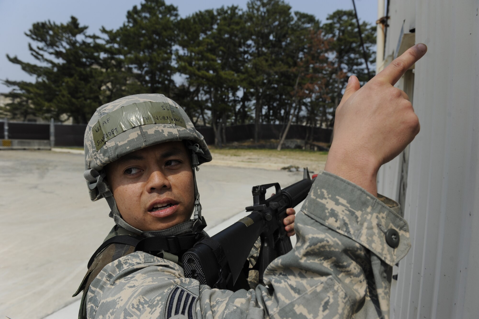 Staff Sgt. Souridet Thongrivong, 8th Civil Engineer Squadron pavements and heavy equipment craftsman, shows another 8th CES Airman where the shooter was during a training exercise at Kunsan Air Base, Republic of Korea, Apr. 10, 2014. The 8th SFS trained the Red Devils on communication tactics, apprehending suspects and manning defensive positions. (U.S. Air Force photo by Staff Sgt. Jessica Haas/Released)