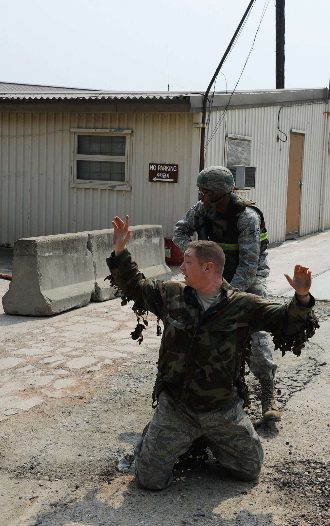 Senior Airman Michael Todd, 8th Civil Engineer Squadron pavements and heavy equipment journeyman, attempts to disarm Staff Sgt. Troy Reed, 8th Security Forces Squadron noncommissioned officer in charge of training, during a training exercise at Kunsan Air Base, Republic of Korea, Apr. 10, 2014. The 8th SFS trained the Red Devils on communication tactics, apprehending suspects and manning defensive positions. (U.S. Air Force photo by Staff Sgt. Jessica Haas/Released)