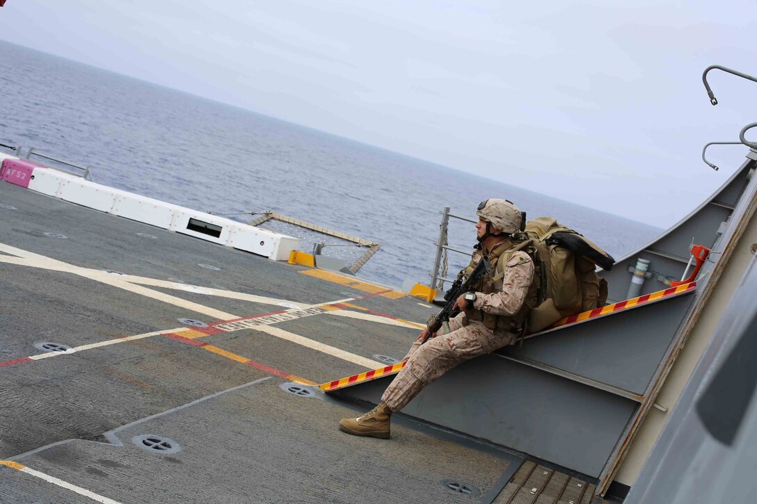 U.S. Marine Corps Sgt. Adrian Garcia, 1st Air Naval Gunfire Liaison Company, 11th Marine Expeditionary Unit, waits to load a helicopter for a training mission during Amphibious Squadron Marine Expeditionary Unit Integration Training (PMINT) off the coast of San Diego, April 10, 2014. PMINT is a two-week predeployment training event focused on the combined capabilities of the MEU and Amphibious Ready Group (ARG), conducting amphibious operations, crisis response and limited contingency operations. (Photo by: U.S. Marine Corps Cpl. Jonathan R. Waldman, 11th Marine Expeditionary Unit Combat Camera/Released)