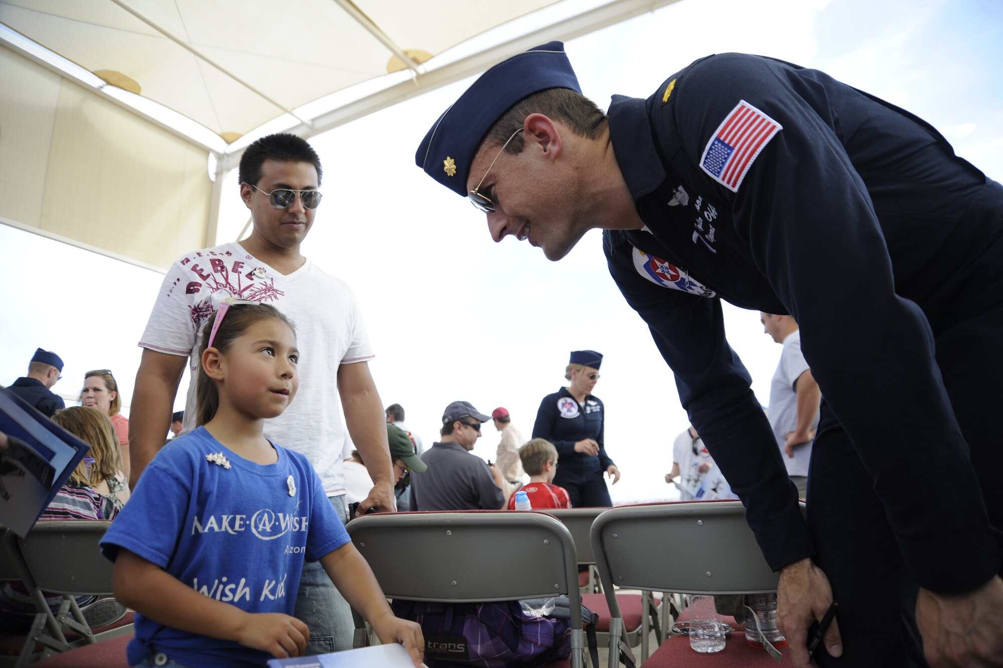 U.S. Air Force Maj. Tyler Ellison, U.S. Air Force Thunderbirds Air Demonstrations Team operations officer, speaks to Layla Reed, a child in the Arizona Make-A-Wish program, at Davis-Monthan Air Force Base, Ariz., April 11, 2014. The Thunderbird pilots autographed books for children in the Arizona Make-A-Wish program during Heroes’ Day. (U.S. Air Force photo by Airman 1st Class Betty R. Chevalier/released)