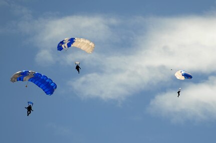 The Wings of Blue Demonstration Team parachutes down for a landing after conducting a free fall during Heroes' Day at Davis-Monthan Air Force Base, Ariz., April 11, 2014. Heroes' Day hosted wounded warriors, disabled children and veterans allowing them personal interaction with the Wings of Blue Demonstration Team, U.S. Air Force Thunderbirds and additional aerial demonstration teams. (U.S. Air Force photo by Cheyenne Morigeau/Released) 