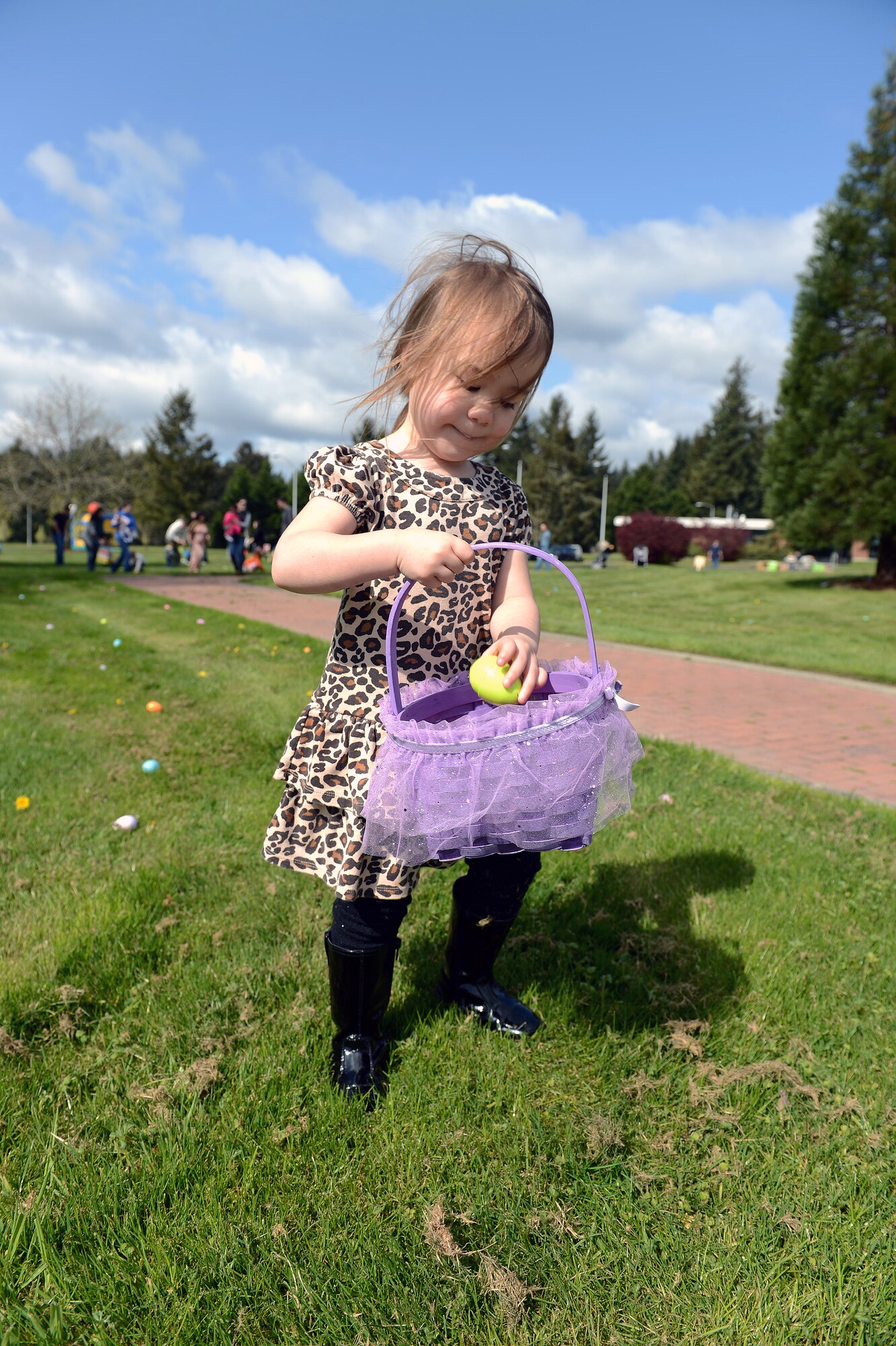Daughter of Tech. Sgt. Shaun Wheeler, 627th Logistics Readiness Squadron quality assurance officer, gathers eggs at the 5/6 Junior NCO Council’s free Easter egg hunt, April 12, 2014 at Joint Base Lewis-McChord, Wash. The event was sponsored by the McChord Spouses Club, First Sergeants Council, The Top Three Council and Operation Warm Heart. (U.S. Air Forces/Airman 1st Class Jacob Jimenez)