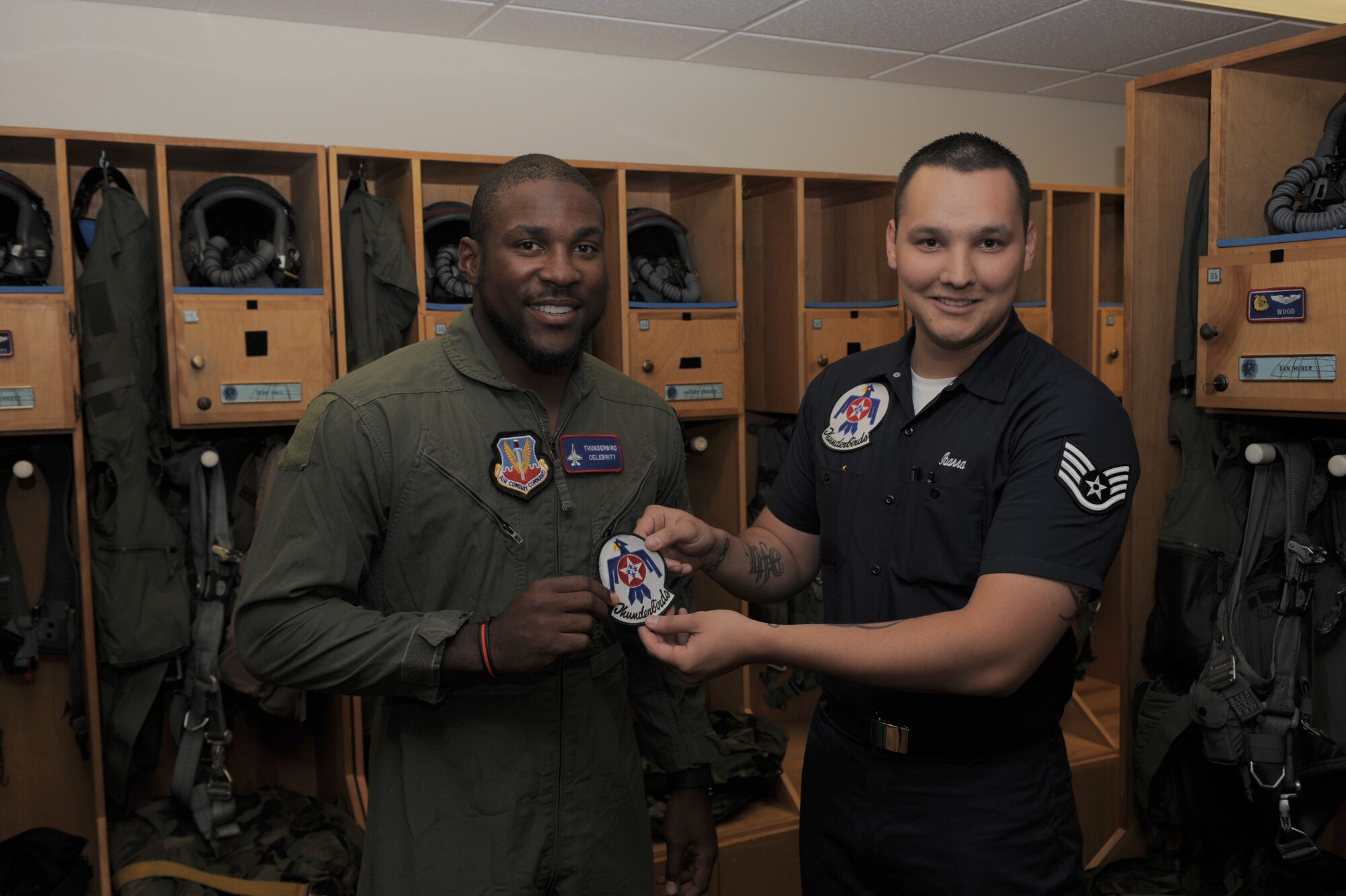 Patrick Peterson, Arizona Cardinals cornerback, receives the U.S. Air Force Thunderbirds patch from Staff Sgt. Jose Ibarra, USAF Thunderbirds Air Demonstration Squadron aircrew flight equipment specialist, at Davis-Monthan Air Force Base, Ariz., April 10, 2014. Peterson was slated for a celebrity orientation flight with the Thunderbirds but it was delayed one day due to aircraft technical difficulty. (U.S. Air Force photo by Airman 1st Class Chris Drzazgowski/Released)