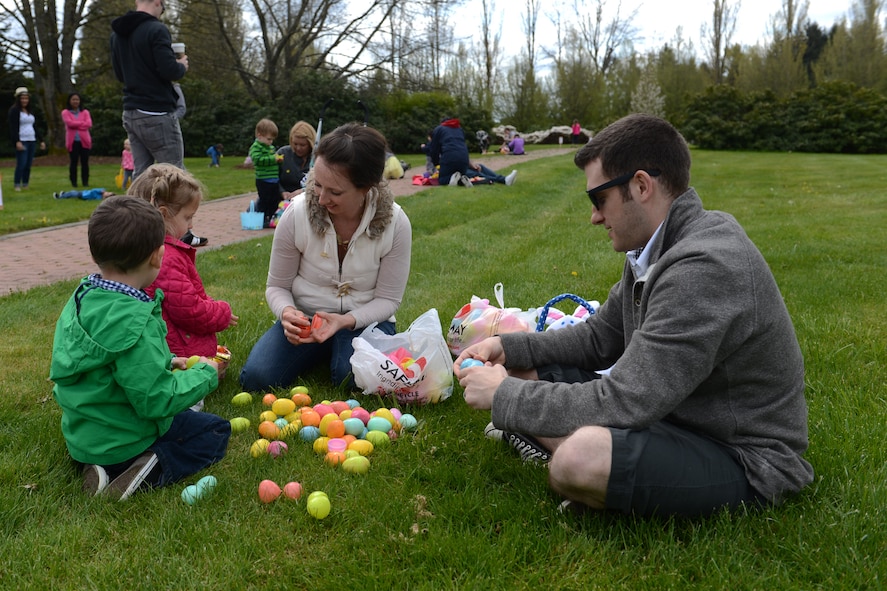 Tech Sgt. Zachery Smith (right), Western Air Defense Sector air surveillance technician, and his family search their Easter eggs for a winning ticket at the 5/6 Junior NCO Council’s free Easter egg hunt, April 12, 2014 at Joint Base Lewis-McChord, Wash. Children who found Easter eggs with winning tickets received Easter baskets or gift cards depending on their age group. (U.S. Air Force photo/Airman 1st Class Jacob Jimenez) 