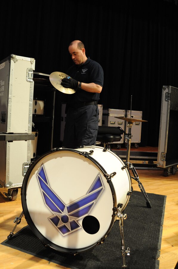 Senior Master Sergeant Robert Kamholz assembles a drum kit prior to a performance by The U.S. Air Force Band at Davison High School in Davison, Mich., April 12, 2014. Kamholz, a native of Lorain, Ohio, is a tour manager for the Band. Before joining the Air Force in 1998, he earned a Bachelor of Fine Arts in Radio and Television Production from Kent State University. (U.S. Air Force photo/Master Sgt. Tammie Moore)