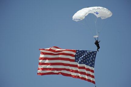U.S. Air Force Cadet 1st Class Brandon Maxson, Wings of Blue Demonstration Team parachutist, displays the American Flag during the Thunder and Lightning over Arizona event at Davis-Monthan Air Force Base, Ariz., April 13, 2014. Wings of Blue displayed seven flags at the event and performed formation flying maneuvers. (U.S. Air Force photo by Airman 1st Class Betty R. Chevalier/released)