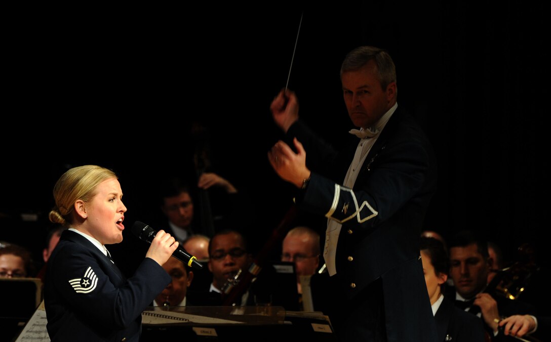 Col. Larry Lang conducts Tech. Sgt. Hannah Rigg as she sings “America the Beautiful” during a performance by The U.S. Air Force Band at Davison High School in Davison, Mich. Lang, a native of El Paso, Texas, is the Band commander and conductor. Rigg, a native of Tomball, Texas, is a soprano vocalist with the Singing Sergeants.  (U.S. Air Force photo/Master Sgt. Tammie Moore)