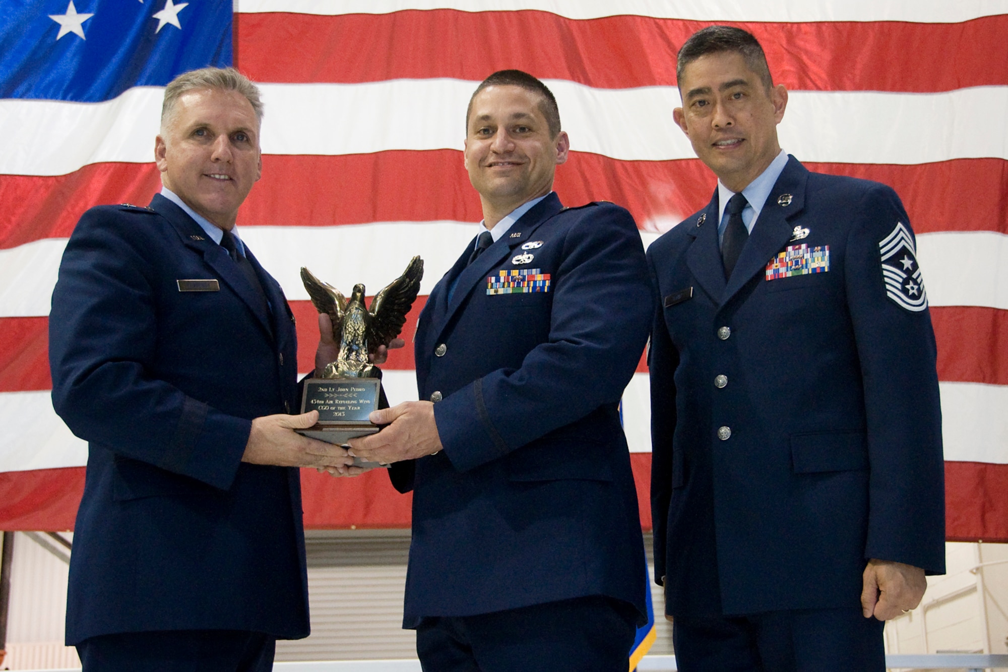 Brig. Gen. John C. Flournoy Jr., 4th Air Force commander, left, and Chief Master Sgt. Brian Wong, 4th AF command chief, right, present 2nd Lt. John Pedro, 434th Logistics Readiness Squadron fuels flight commander, with a 434th Air Refueling Wing Officer of the Year for 2013 award at an annual awards banquet held at Grissom Air Reserve Base, Ind., April 12, 2014. Each year, time is set aside to honor Grissom Airmen who embody the Air Force's core values to the fullest extent through their actions and commitment to duty. (U.S. Air Force photo/Staff Sgt. Andrew McLaughlin)
