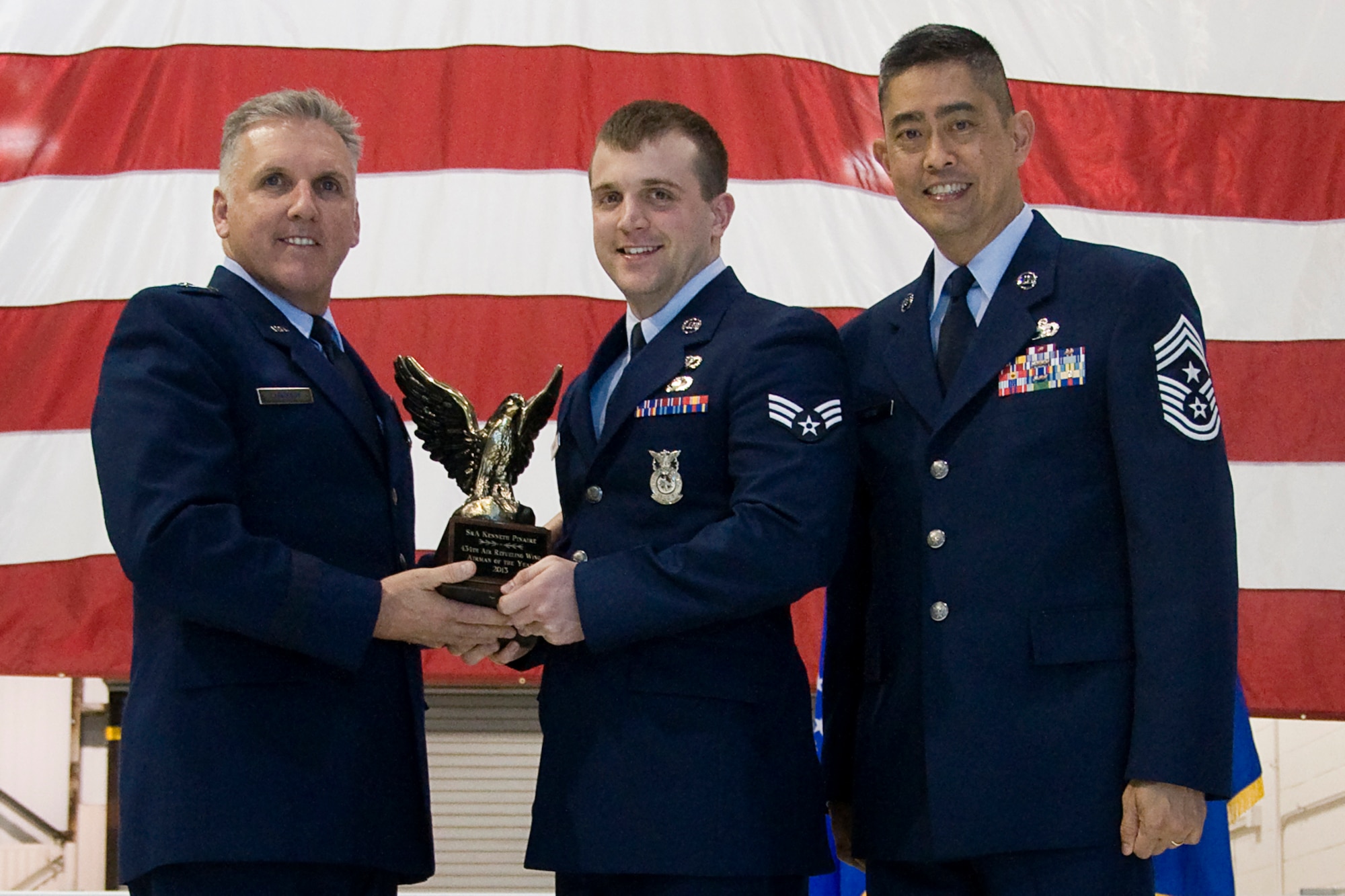 Brig. Gen. John C. Flournoy Jr., 4th Air Force commander, left, and Chief Master Sgt. Brian Wong, 4th AF command chief, right, present Senior Airman Kenneth Pinaire, 434th Civil Engineer Squadron fire protection apprentice, with a 434th Air Refueling Wing Airman of the Year for 2013 award at an annual awards banquet held at Grissom Air Reserve Base, Ind., April 12, 2014. Each year, time is set aside to honor Grissom Airmen who embody the Air Force's core values to the fullest extent through their actions and commitment to duty. (U.S. Air Force photo/Staff Sgt. Andrew McLaughlin)
