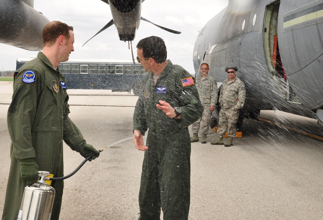 Tech. Sgt. Jason Garner, 932nd Aeromedical Evacuation Squadron(AES) Technician, sprays down Maj. Bruce Schlager, 932nd AES Flight Nurse, after his final flight, as crewmembers look on.  Schlager served for thirty-two years, twenty-two of which were enlisted, and ten as an officer.  Schlager had this to say about his last flight with the unit "I'm sad but happy, and ready to take the next step in life". He retires on the same weekend his daughter will start as a commissioned officer for the 932nd Maintenance Squadron. (U.S. Air Force Photo/ Staff Sgt. Amber Hodges)