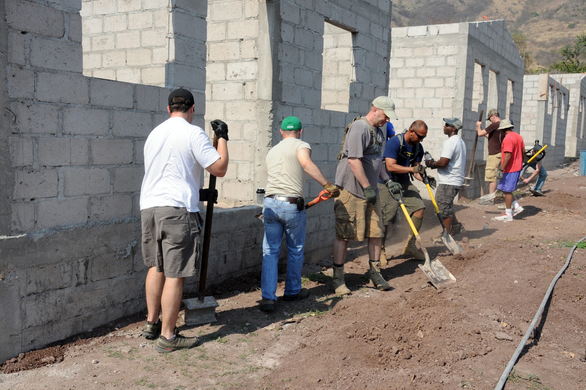 Twenty-one Joint Task Force-Bravo service members filled trenches, leveled ground and shoveled dirt at the Ajuterique Housing Project helping several Honduran families get closer to moving into their new homes April 5, 2014.  In conjunction with the Honduras Habit for Humanity, Siguatepeque region, the Municipality of Ajuterique and the Civil-Military Operations office at JTF-Bravo, these service members volunteered their labor to assist in the building of homes in the Ajuterique community.  The two-phased project includes building 38 two-bedroom, one-bath homes for low-income Hondurans who can afford to construct a home but doesn't own the land to build on. (Photo by U. S. Air National Guard Capt. Steven Stubbs)