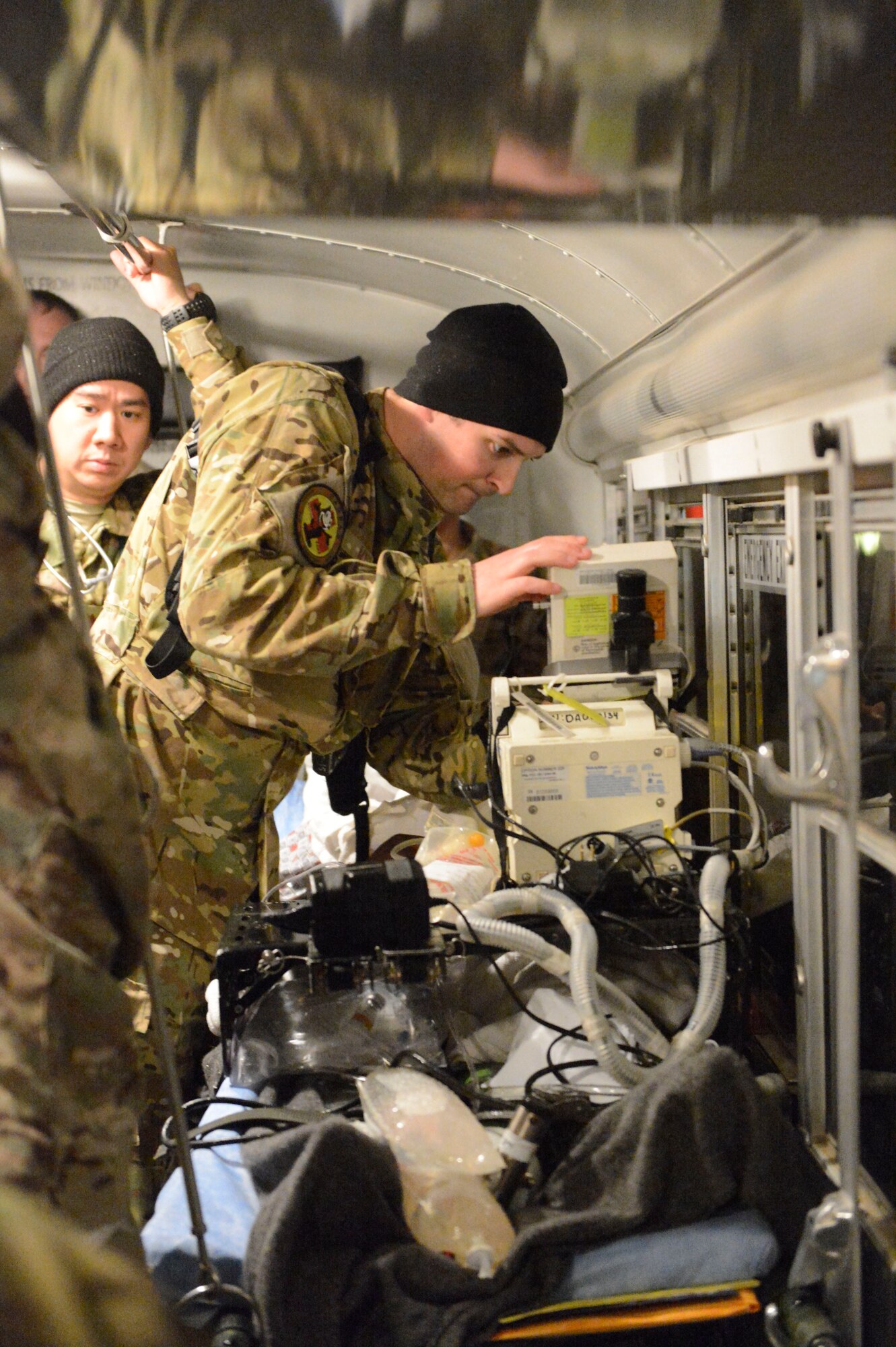 U.S. Air Force Capt. Jason Melvin, critical care nurse, of the 455th Expeditionary Aeromedical Evacuation Squadron, Bagram Airfield, Afghanistan, monitors a patient during a bus transport between the Kandahar Airfield hospital and a C-130J Super Hercules used to fly the patient to a higher level of care, April 3, 2014. Melvin is a member of the Critical Care Air Transport Team, and deployed from Eglin Air Force Base, Fla.(U.S. Air Force photo by Senior Master Sgt. Gary J. Rihn/Released)