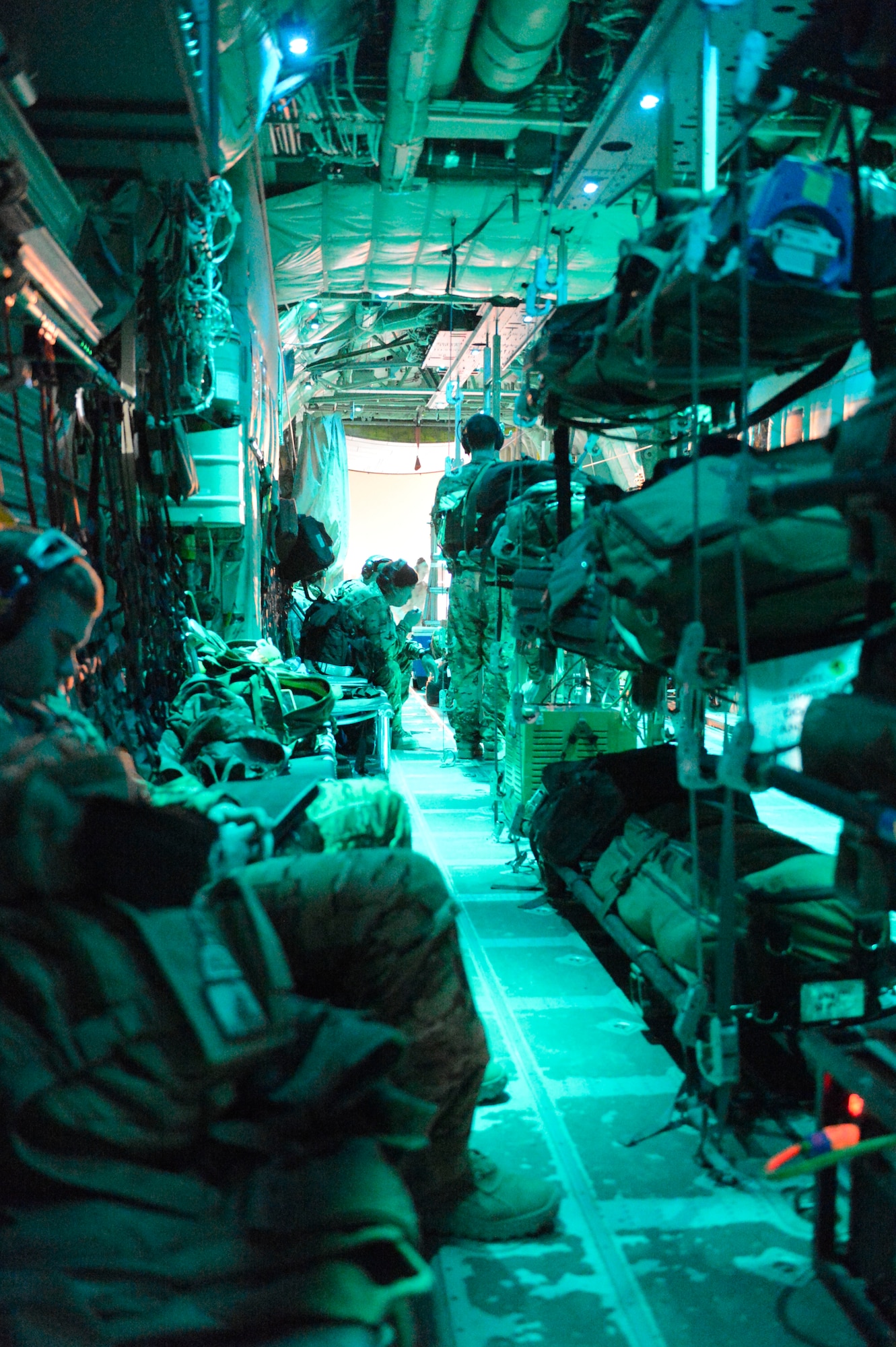 Members of the 455th Expeditionary Aeromedical Evacuation Squadron await the delivery of a patient on a C-130J Super Hercules from Herat, Afghanistan, April 3, 2014. The team was flying on a mission to different locations around Afghanistan to pick up and deliver medical patients.(U.S. Air Force photo by Senior Master Sgt. Gary J. Rihn/Released)  