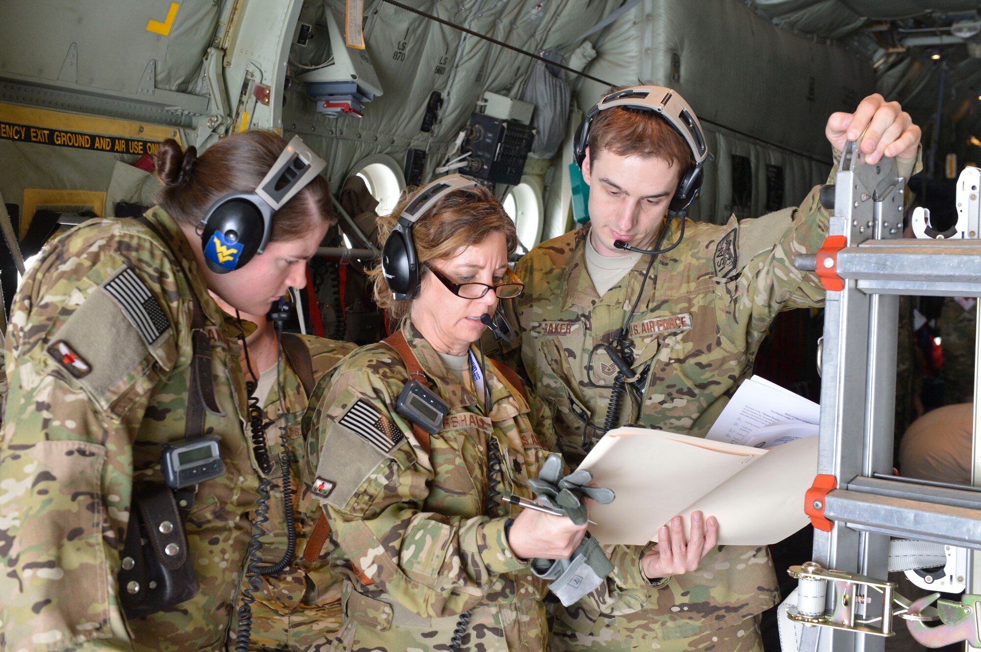 U.S. Air Force 1st Lt. Erica Hanshew, Lt. Col. Barb Marshall and Tech. Sgt. Troy Baker of the 455th Expeditionary Aeromedical Evacuation Squadron, Bagram Airfield, Afghanistan, look at the medical info for a patient about to be loaded at Herat, Afghanistan, April 3, 2014. The three are part of a team deployed to Bagram from the West Virginia Air National Guard.(U.S. Air Force photo by Senior Master Sgt. Gary J. Rihn/Released)