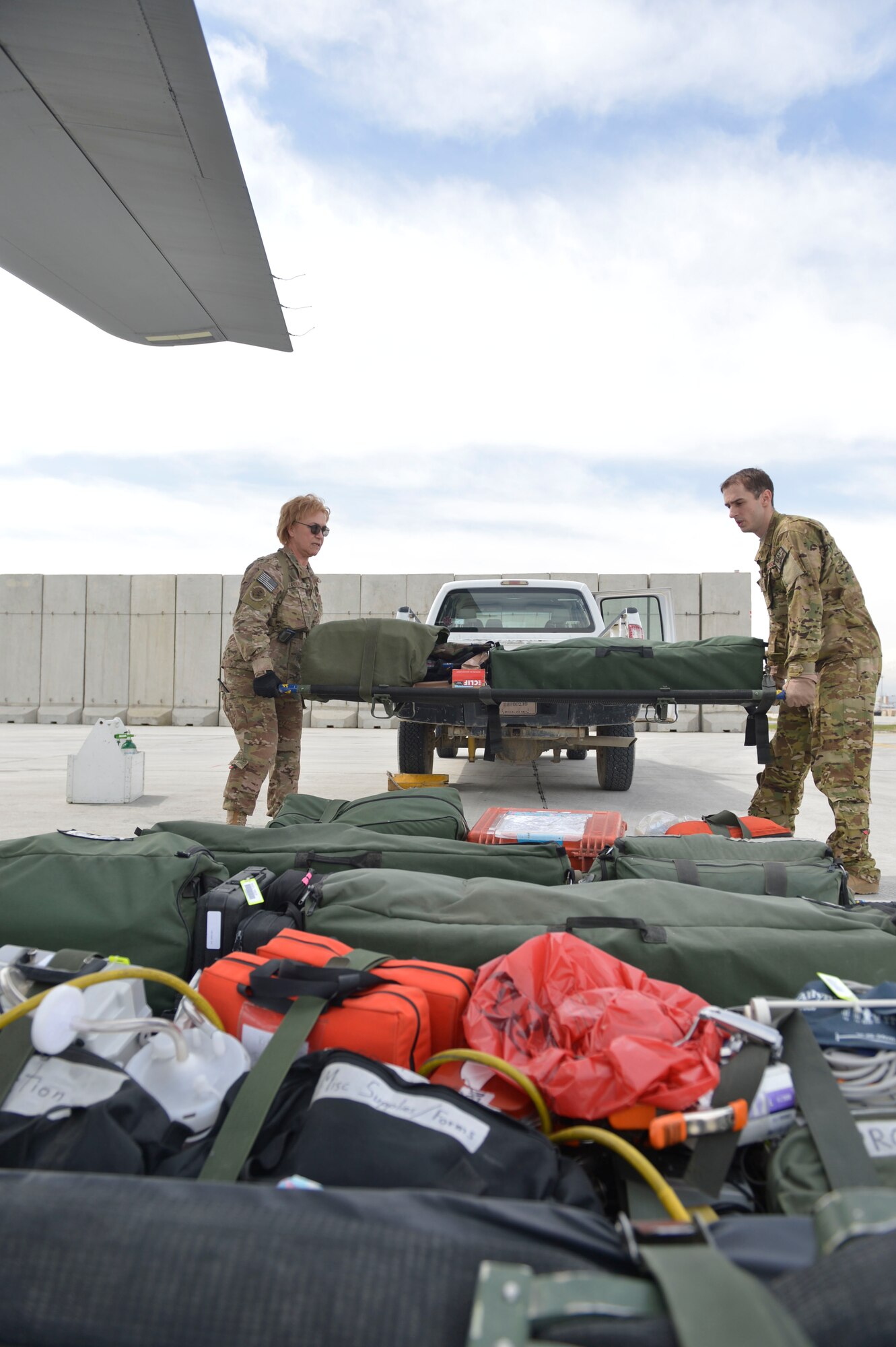 U.S. Air Force Lt. Col. Jeanne LaFountain and Tech. Sgt. Troy Baker of the 455th Expeditionary Aeromedical Evacuation Squadron, Bagram Airfield, Afghanistan, prepare to load stretchers full of medical equipment on to a C-130J Super Hercules, April 3, 2014. The team was preparing to fly to different locations around Afghanistan to pick up and deliver medical patients.(U.S. Air Force photo by Senior Master Sgt. Gary J. Rihn/Released)