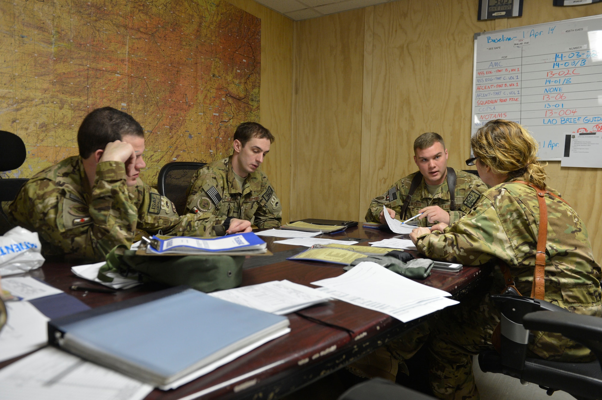 Members of the 455th Expeditionary Aeromedical Evacuation Squadron confer during a pre-mission brief at Bagram Airfield, Afghanistan, April 3, 2014. The team was preparing to fly to different locations around Afghanistan to pick up and deliver medical patients.(U.S. Air Force photo by Senior Master Sgt. Gary J. Rihn/Released)