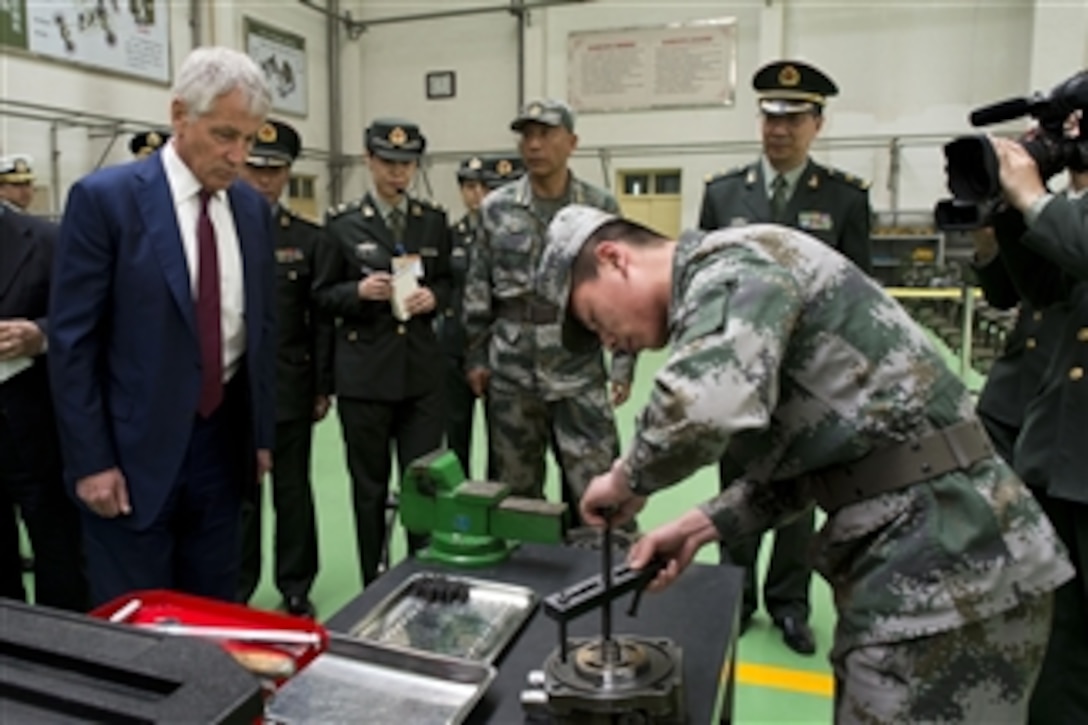 U.S. Defense Secretary Chuck Hagel receives a tour from a Chinese military officer at the Noncommissioned Officer Academy in Beijing, April 9, 2014. During the tour, Hagel saw the school, observed other demonstrations on training and simulations, and ate lunch with students and Chinese officers.