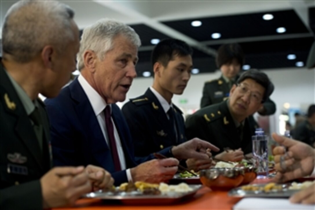 U.S. Defense Secretary Chuck Hagel receives a tour from a Chinese military officer at the Noncommissioned Officer Academy in Beijing, April 9, 2014. During the tour, Hagel saw the school, observed other demonstrations on training and simulations, and ate lunch with students and Chinese officers.
