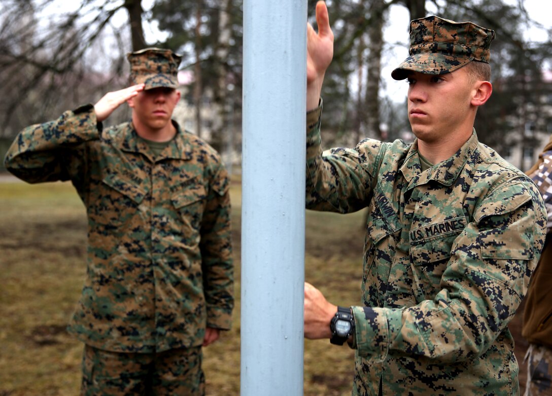 Corporal Benjamin Kirwin, a mortarman with 3rd Battalion, 8th Marine Regiment, 2nd Marine Division assigned to Black Sea Rotational Force 14, raises the American Flag during the opening ceremony for the beginning of Summer Shield while Cpl. Christian Doran salutes, aboard Camp Adazi, Latvia, April 7, 2014. This is the 11th iteration of the Summer Shield exercise, a joint staff planning and combined arms live fire maneuver event designed to enhance the Latvian Land Force’s capacity and capability to integrate fires and maneuver at the battalion and brigade level as well as increase partner capacity, promote regional stability, and continue to develop Latvian, Lithuanian, Estonian and U.S. interoperability. (Official Marine Corps photo by Lance Cpl. Scott W. Whiting, BSRF PAO/ Released)