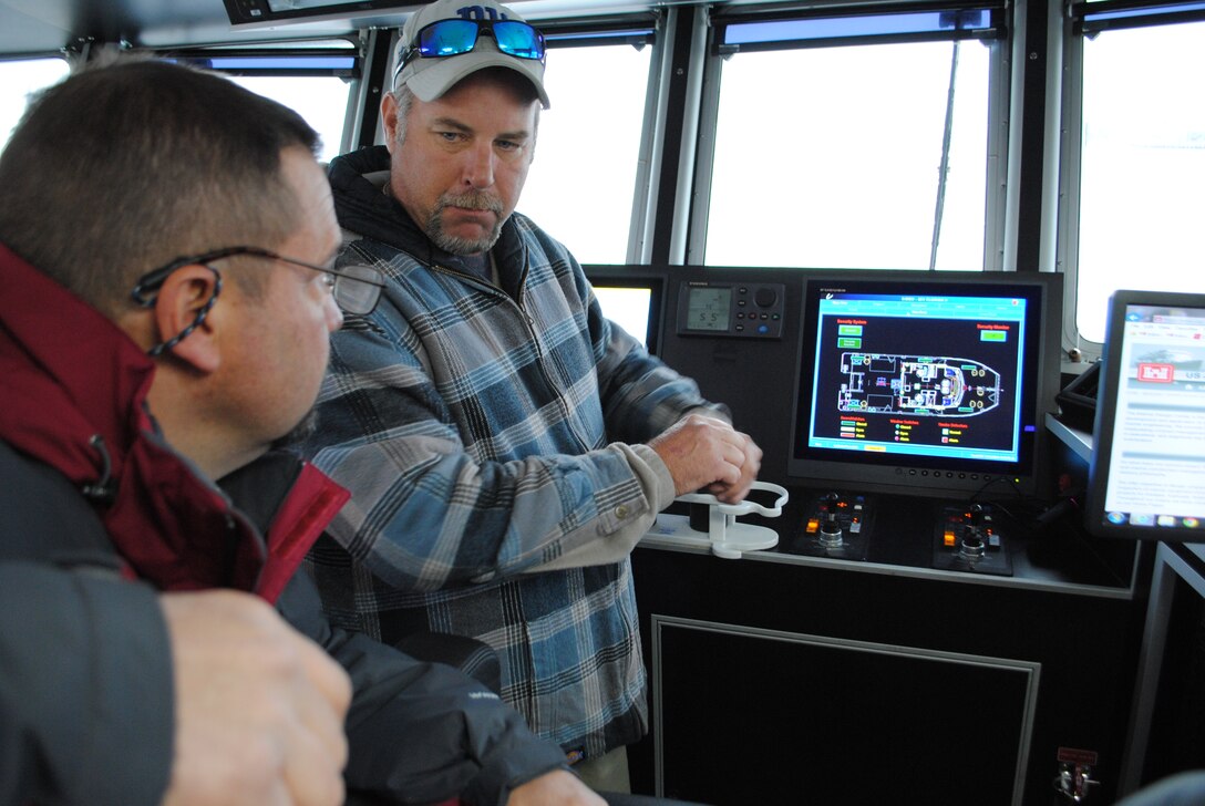 Florida II captain Rory Riker (right) demonstrates the navigation systems aboard Jacksonville District’s newest survey vessel to visitors during an event this winter near Fernandina Beach.  The Corps’ Marine Design Center, based in Philadelphia District, invited visitors from four other districts who want to upgrade their fleets, to see what options are available for consideration. (Photo by John Campbell)