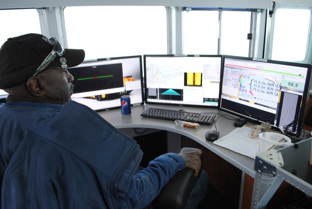 Jacksonville District surveyor Robert Jenkins observes data as it pops up on computer screens while running surveys near Fernandina Beach. Jenkins was demonstrating the state-of-the-art equipment aboard the Florida II as part of a Marine Design Center demonstration on the vessel’s capabilities. (Photo by John Campbell)