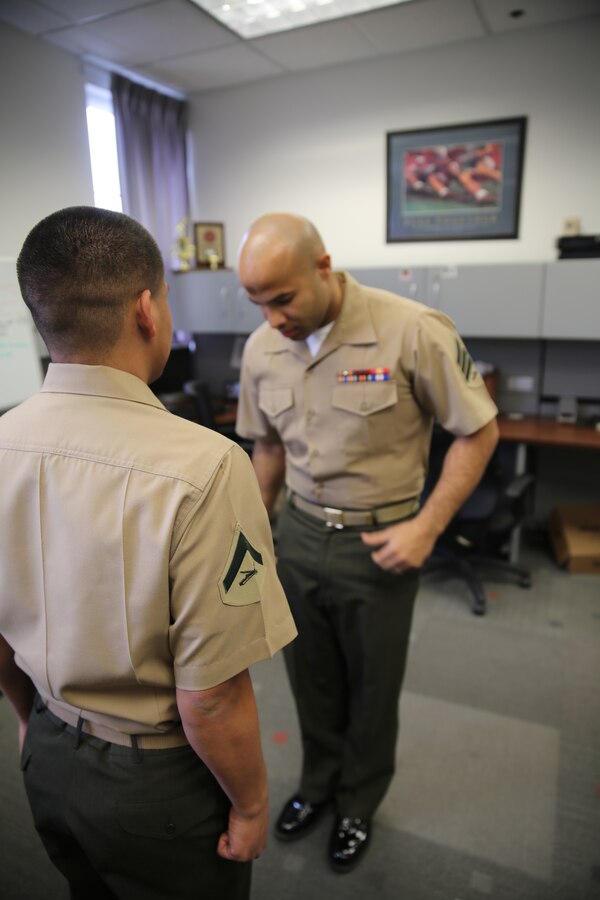 Sergeant Julio Acevedo (right), non-commissioned officer of the quarter on Marine Corps Logistics Base Barstow, Calif., passes on his experience of winning a board to a junior Marine, April 4. Having a squared away uniform, knowledge of the Marine Corps and bearing are imperative to being successful on any board.
