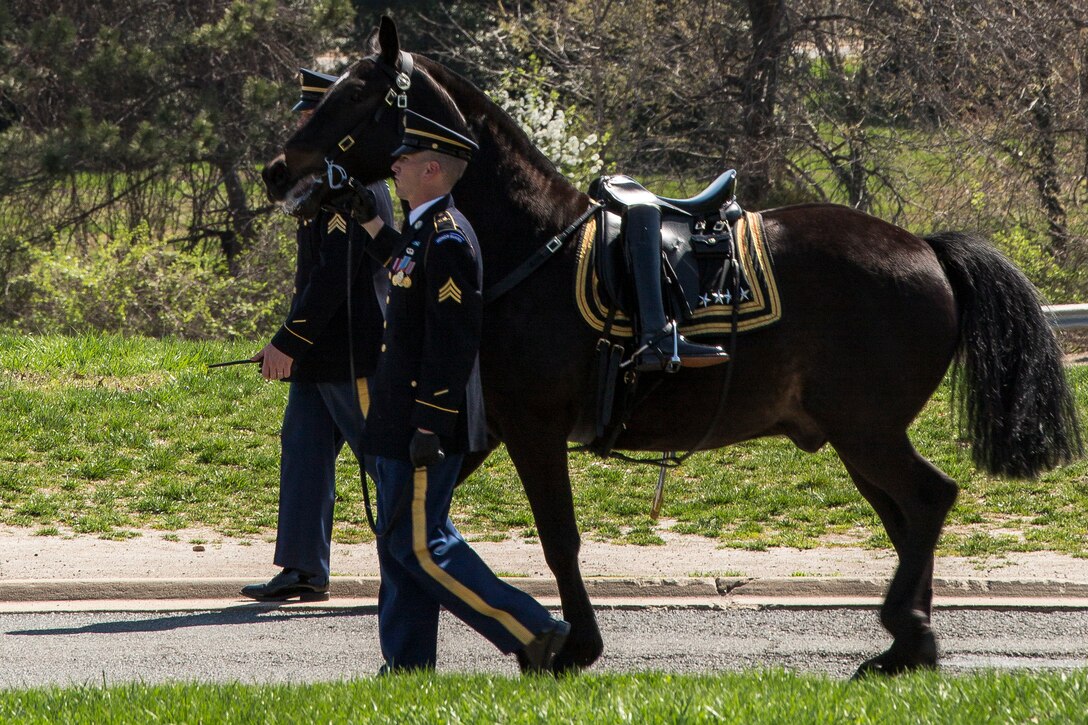 Soldiers at Arlington National Cemetery guide a horse towards the Marine Corps War Memorial as it carries a pair of empty, backwards-facing boots during a memorial ceremony for Gen. Carl E. Mundy, 30th commandant of the Marine Corps, April 12, 2014. The boots symbolize the deceased leader facing his troops for the last time. Gen. James F. Amos, commandant of the Marine Corps, and Sgt. Maj. Michael P. Barrett, sergeant major of the Marine Corps, were in attendance at the ceremony. (Official Marine Corps photo by Cpl. Dan Hosack/Released)