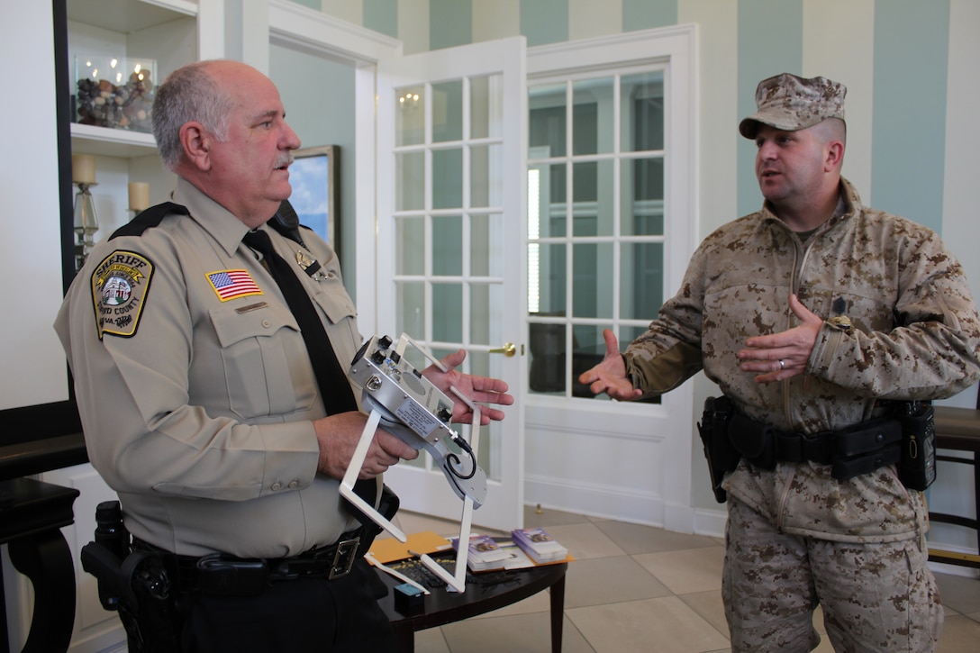Deputy J.L. Hamilton, crime prevention deputy at the Stafford County Sheriff’s Office, and Gunnery Sgt. Mark Vesely, watch commander at the Provost Marshal’s Office aboard Marine Corps Base Quantico, discuss details on a pulse-carrier wave frequency tool that is used to track wandering persons with mental or developmental disorders at the McHugh Woods Community Center on March 24, 2014. Hamilton demonstrated “Project Life Saver,” a tracking system for lost individuals, to Quantico families and police officers at McHugh Woods Community Center on March 24, 2014.