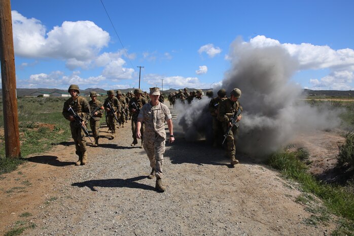 Marines of Company H, 2nd Recruit Training Battalion, walk in a combat patrol formation through an Improvised Explosive Device course during the Crucible at Edson Range aboard Marine Corps Base Camp Pendleton, April 1. The road they patrolled consisted of several suspicious objects such as a totaled car on the side of the road.