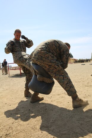Two recruits of Company K, 3rd Recruit Training Battalion, execute kicks learned during the Marine Corps Martial Arts Program aboard the depot, March 29. Recruits were split into groups of 25 to run through the course.