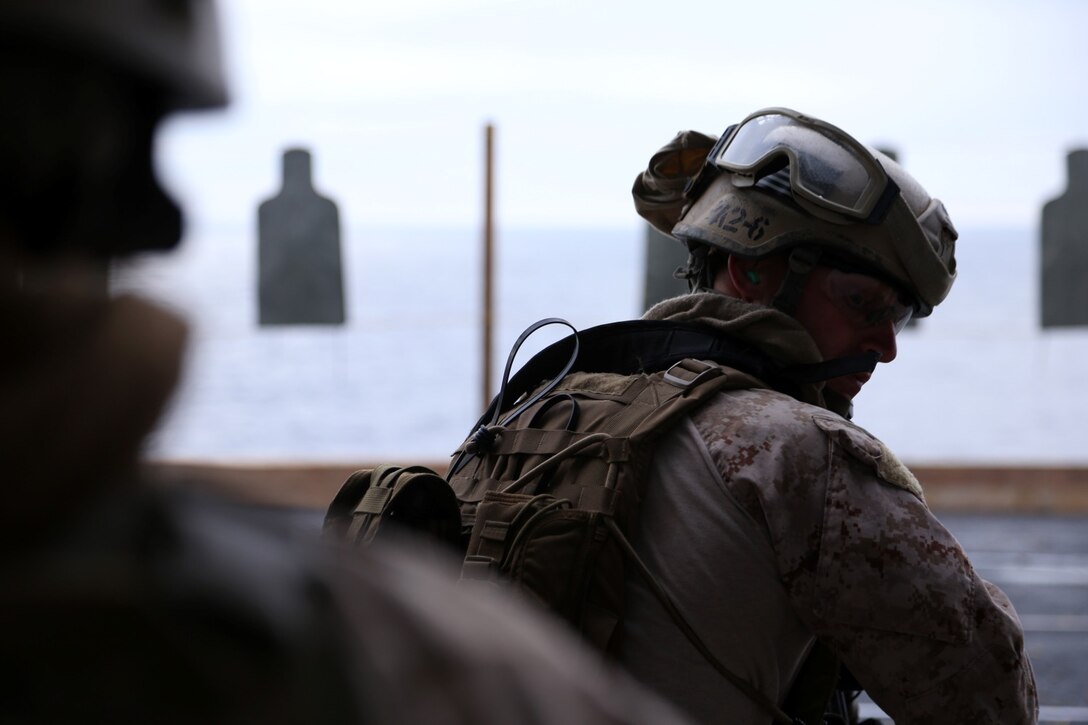 A Marine with the Maritime Raid Force, 11th Marine Expeditionary Unit, checks his sides after engaging his targets as part of combat drills on the air cargo elevator of the USS Makin Island during Amphibious Squadron Marine Expeditionary Unit Integration Training (PMINT), off the coast of San Diego, Calif., April 10, 2014. PMINT is a two-week long pre-deployment training event focusing on the combined capabilities of the Marine Expeditionary Unit and Amphibious Ready Group (ARG), conducting amphibious operations, crisis response and limited contingency operations. (U.S. Marine Corps photo by Gunnery Sgt. Rome M. Lazarus/Released)
