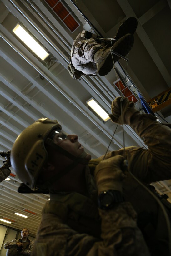 Marines with the Maritime Raid Force, 11th Marine Expeditionary Unit, conduct vessel boarding drills in the hangar bay of the USS Makin Island during Amphibious Squadron Marine Expeditionary Unit Integration Training (PMINT), off the coast of San Diego, April 11, 2014. PMINT is a two-week long predeployment training event focusing on the combined capabilities of the Marine Expeditionary Unit and Amphibious Ready Group (ARG), conducting amphibious operations, crisis response and limited contingency operations. (U.S. Marine Corps photo by Gunnery Sgt. Rome M. Lazarus/Released)