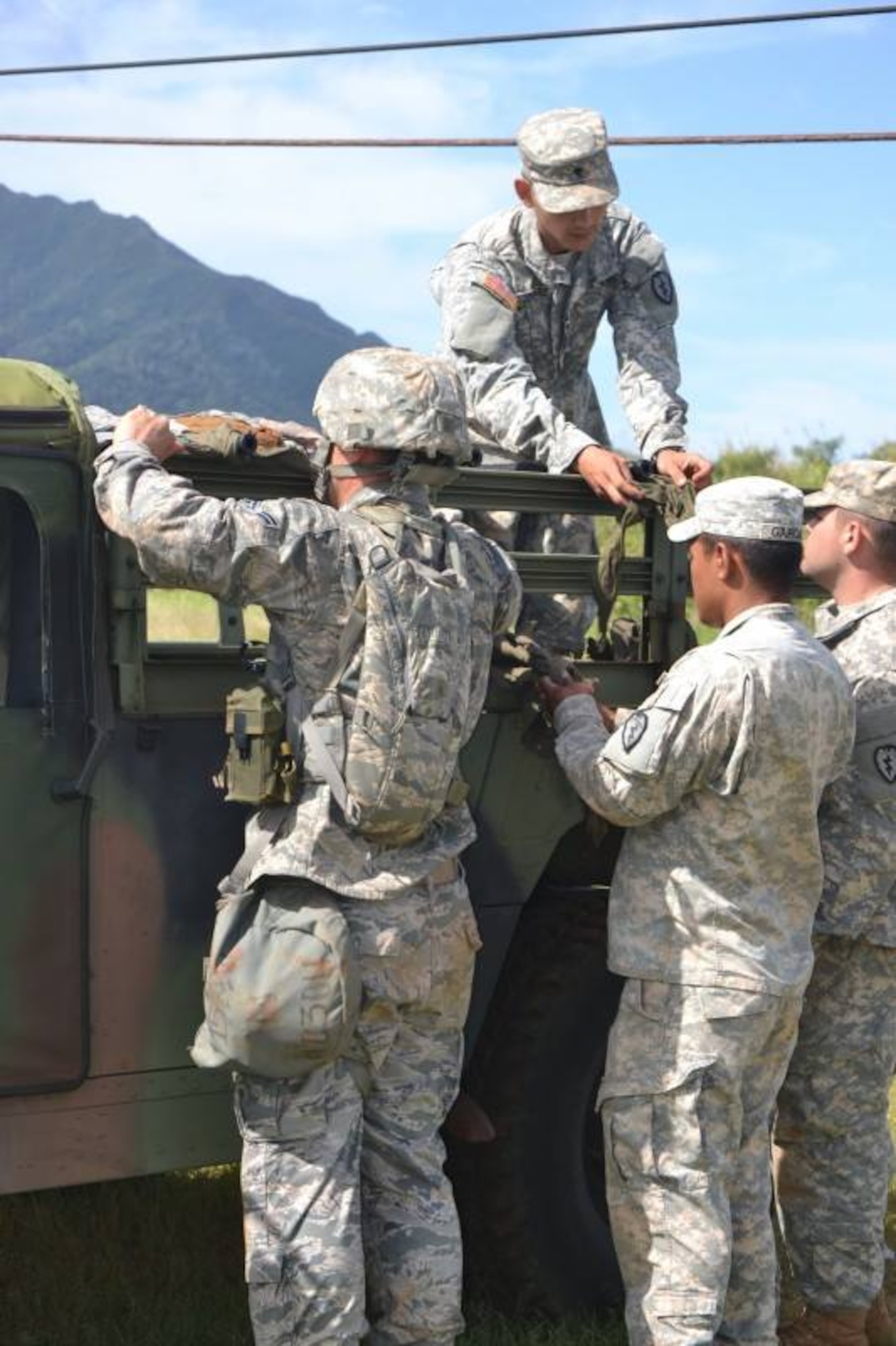 Four Expert Field Medical Badge course candidates tie a litter to the back of a HUMVEE during the EFMB course, which was held at Schofield Army Barracks, Hawaii, March 31 through April 11, 2014. The candidates had to demonstrate their ability to load a casualty onto a standard and non-standard platform. Additionally, to successfully complete the course, students had to demonstrate their proficiency at tactical combat casualty care, take a written test, execute U.S. Army Warrior communications and chemical, biological, radiological, nuclear and high-yield explosives tasks, perform day and night land navigation and complete a 12-mile road march. (U.S. Army photo courtesy of 25th Infantry Division)
 
