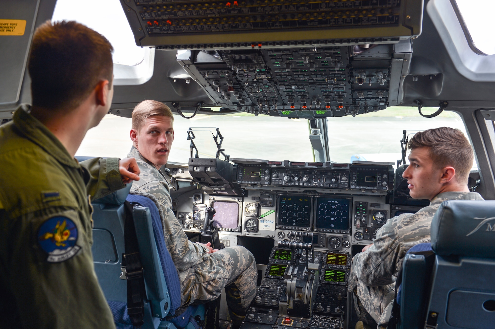 1st Lt. James Cushing (left), 4th Airlift Squadron pilot, discusses the process of becoming a C-17 Globemaster III pilot to Cadets Karson Roberts and Michael Roe, Air Force Academy students, April 11, 2014 at Joint Base Lewis-McChord, Wash. The cadets hope to be selected for flight school and enjoyed the opportunity to speak with pilots who were previous USAFA graduates. (U.S. Air Force photo/Staff Sgt. Russ Jackson) 