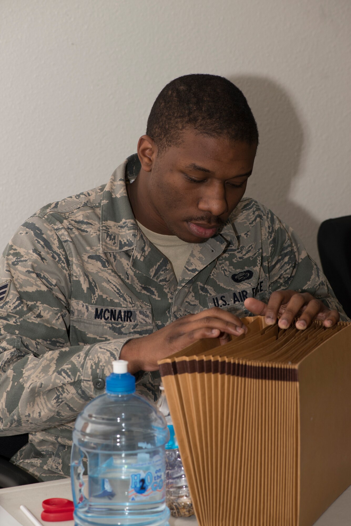 Senior Airman Karon McNair, 366th Force Support Squadron customer support journeyman, searches files while Airmen in-process during a base wide exercise April 14, 2014, Mountain Home Air Force Base, Idaho. As part of the exercise, Airmen in-process during the transition phase of the exercise, simulating deployment to a war zone. (Air Force photo by Airman 1st Class Malissa Lott)