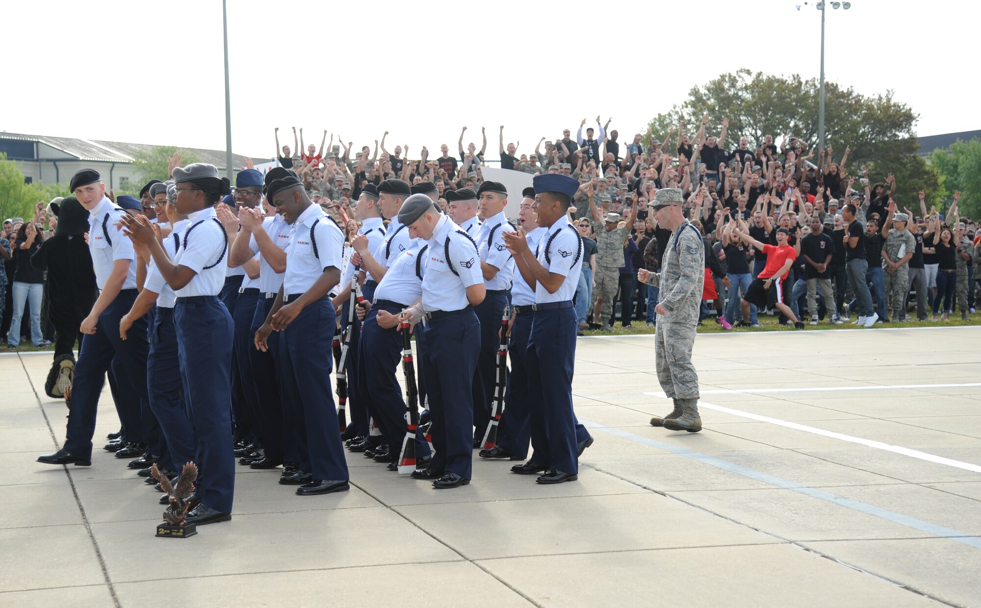 Members of the 335th Training Squadron drill teams and fellow Airmen cheer during the 81st Training Group’s drill down competition as the announcement is made that they were the overall winners for the competition April 11, 2014, behind the Levitow Training Support Facility, Keesler Air Force Base, Miss.  The 335th TRS placed 1st in regulation and 2nd in open ranks and freestyle.  (U.S. Air Force photo by Kemberly Groue)
