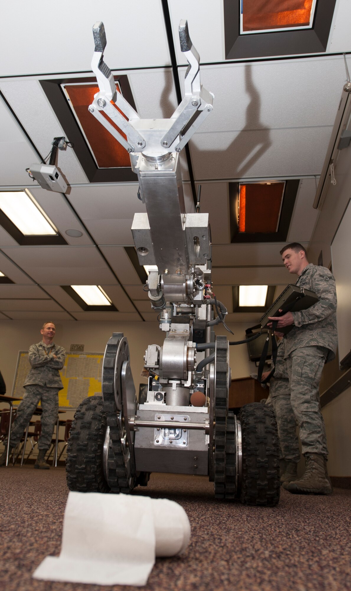 Airman 1st Class Justin Davis, 5th Civil Engineer Squadron EOD equipment, operates a robot during a demonstration at the Magic City Campus in Minot, N.D., April 11, 2014. The robot was on display and demonstrations performed for students during an event that featured members of EOD showing off gear and fielding questions. (U.S. Air Force photo/Senior Airman Andrew Crawford)