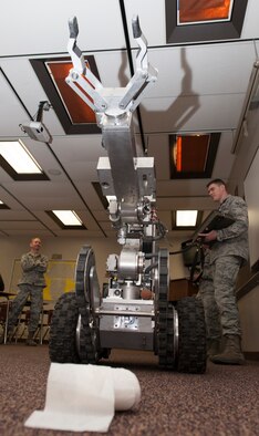 Airman 1st Class Justin Davis, 5th Civil Engineer Squadron EOD equipment, operates a robot during a demonstration at the Magic City Campus in Minot, N.D., April 11, 2014. The robot was on display and demonstrations performed for students during an event that featured members of EOD showing off gear and fielding questions. (U.S. Air Force photo/Senior Airman Andrew Crawford) 

