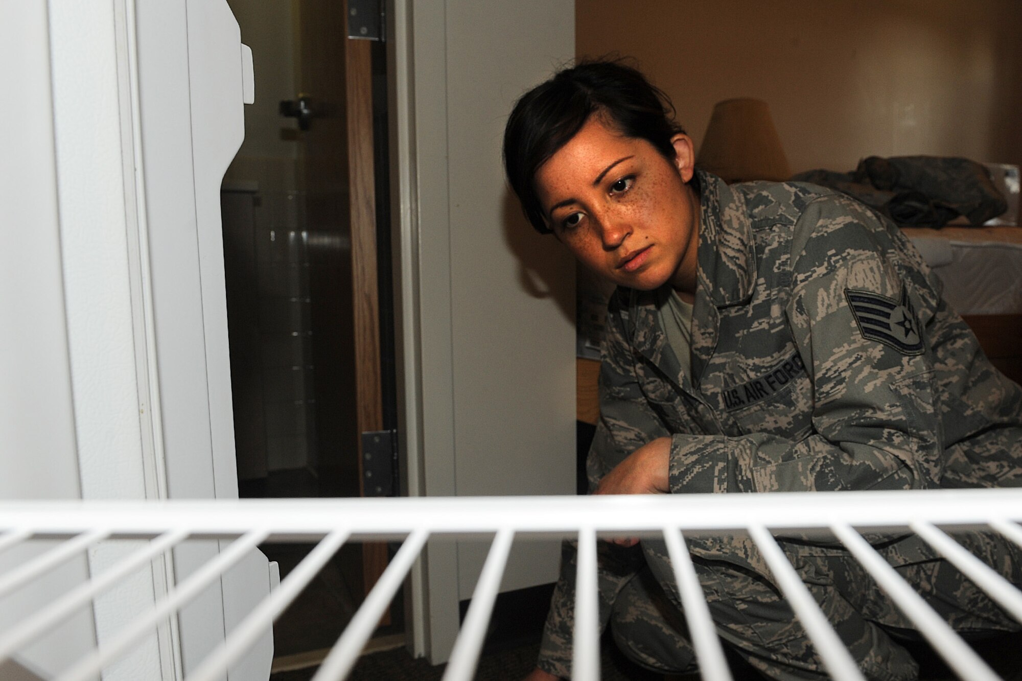 Staff Sgt. Erika Wenzel inspects a refrigerator during a room inspection at Scott Air Force Base, Ill., March 31, 2014. As part of the dormitory management team, she inspects the cleanliness of the rooms in the Belleville, Shiloh and Mascoutah dorms.  She is responsible for mentoring and counseling more than 380 Airmen.  Wenzel is a 375th Civil Engineering Squadron Airman dormitory leader.  (U.S. Air Force photo by Staff Sgt. Maria Bowman)