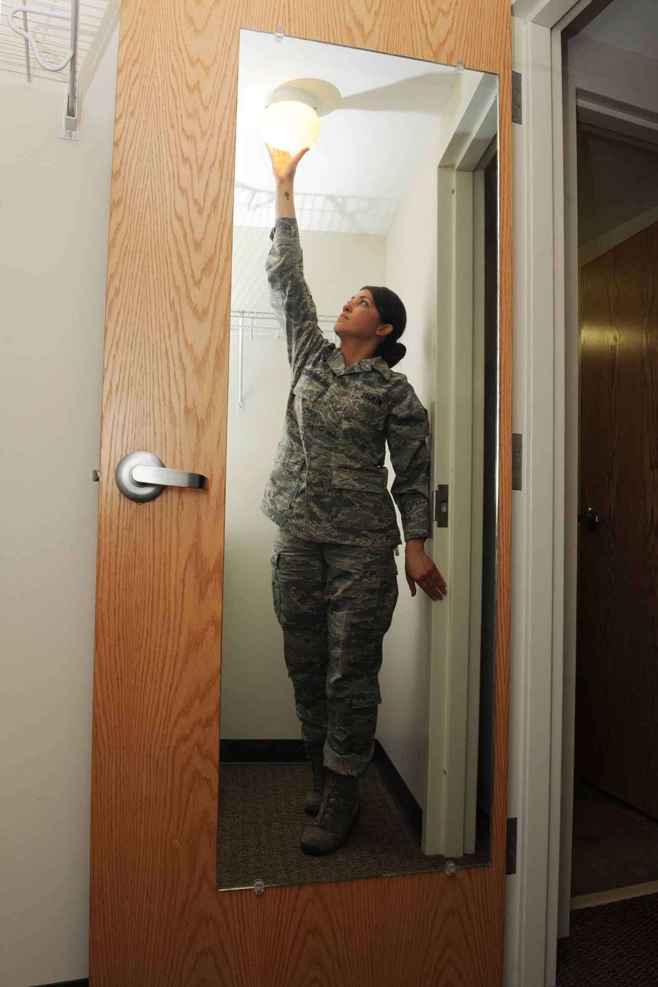 Staff Sgt. Erika Wenzel checks a closet light during a room inspection at Scott Air Force Base, Ill., March 31, 2014.  If something is broken, Wenzel coordinates with the correct offices to fix the problem.  Wenzel is responsible for taking care of more than 380 Airmen throughout three dormitories: Belleville, Shiloh and Mascoutah.  Wenzel is a 375th Civil Engineering Squadron Airman dormitory leader.  (U.S. Air Force photo by Staff Sgt. Maria Bowman)