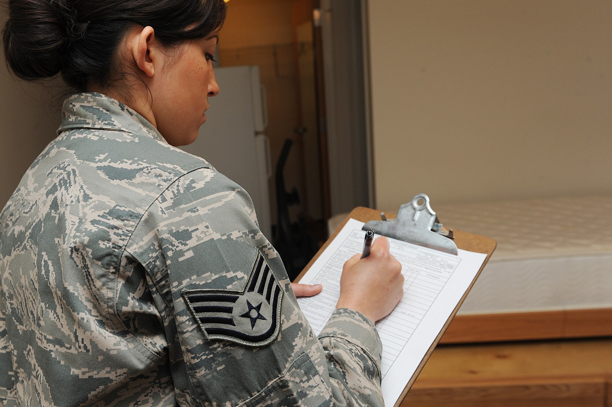 Staff Sgt. Erika Wenzel checks off discrepancies during a room inspection at Scott Air Force Base, Ill., March 31, 2014.  As part of the dormitory management team, Wenzel is also responsible for taking care of more than 380 single Airmen throughout three dormitories: Belleville, Shiloh and Mascoutah.  Wenzel is a 375th Civil Engineering Squadron Airman dormitory leader.  (U.S. Air Force photo by Staff Sgt. Maria Bowman)