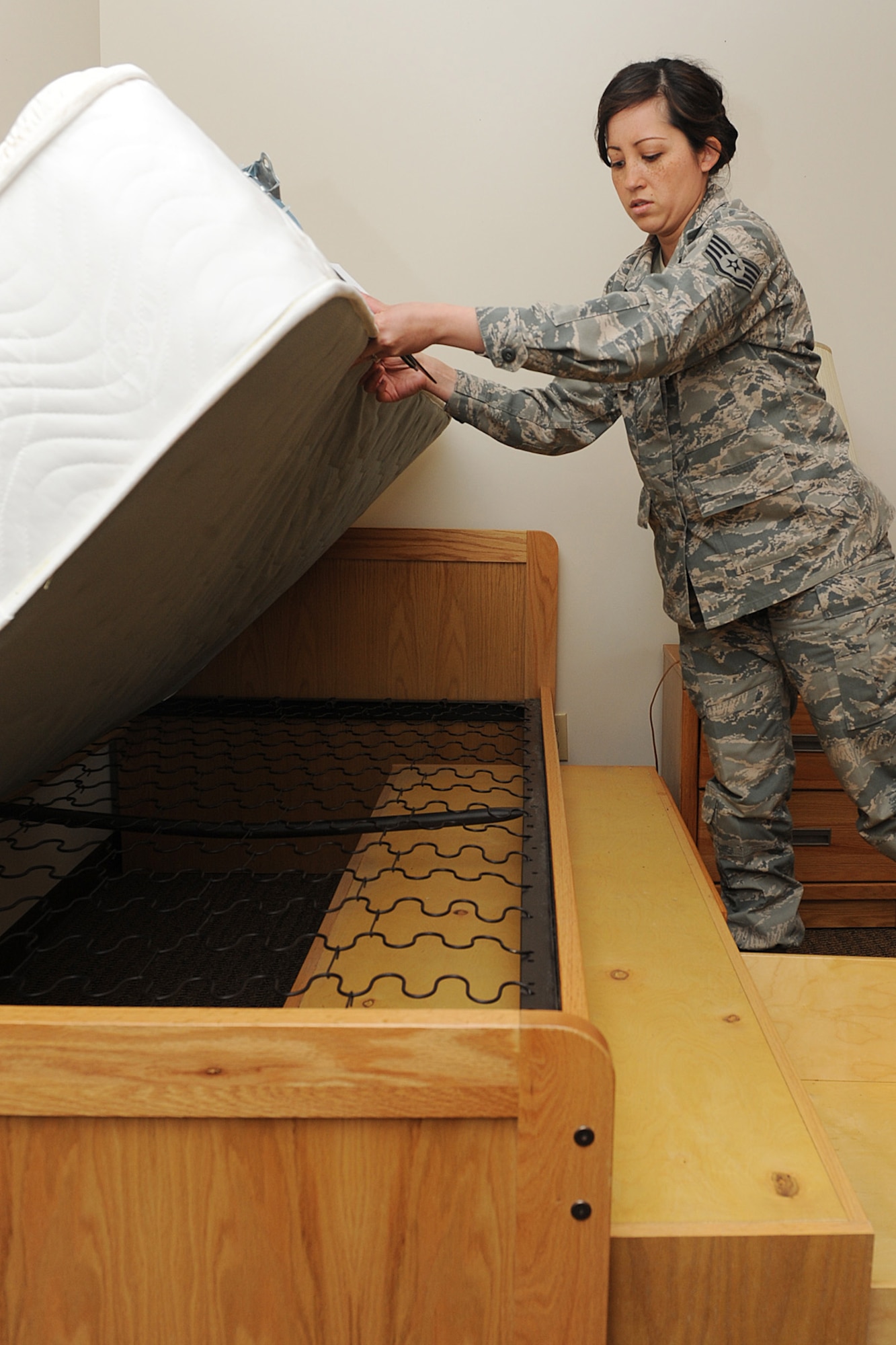 Staff Sgt. Erika Wenzel inspects under a mattress during a room inspection at Scott Air Force Base, Ill., March 31, 2014. As part of the dormitory management team, she inspects the cleanliness of the rooms in the Belleville, Shiloh and Mascoutah dorms.  She is responsible for more than 380 Airmen.  Wenzel is a 375th Civil Engineering Squadron Airman dormitory leader.  (U.S. Air Force photo by Staff Sgt. Maria Bowman)