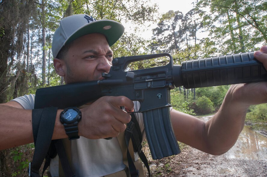 A member of the Opposing Forces (Op-4) shoots blanks out of an M16 assault rifle during a Combat Survival Training exercise at Moody Air Force Base, Ga., April 8, 2014. The Op-4 create simulated chaos for the training using mock assault rifles, hand grenades and smoke grenades. (U.S. Air Force photo by Airman Dillian Bamman/Released)